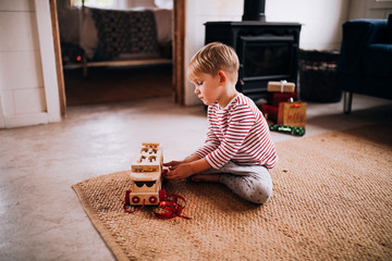 Boy plays with new wooden toy truck