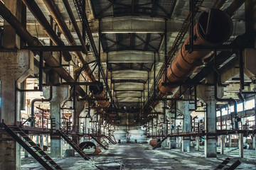 Abandoned Industrial workshop or hall of production for heavy industry factory . Huge steel pipes...