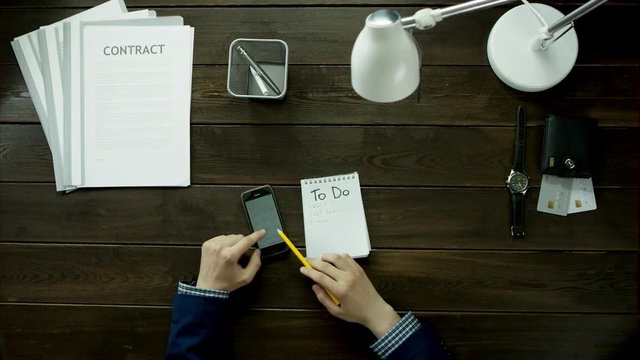 The man count in the calculator information from notebook with his expenses.