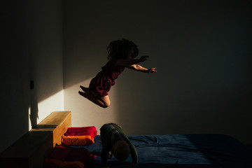 kids play on bed in a warm light