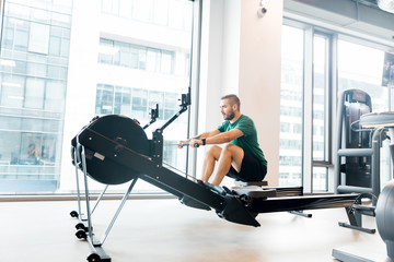 Active athlete man doing rowing workout