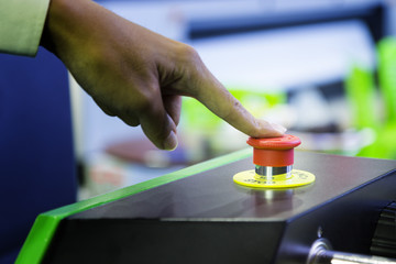 emergency stop button push by finger for stopping machine