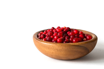 Berries of a cranberry in a wooden bowl on a white background isolate close-up