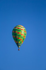 A beautiful colorful hot air baloon flying over the autumn swamp. Sunny wetland landscape in morning with balloon in Latvia.