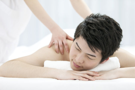 Woman receiving back massage at spa