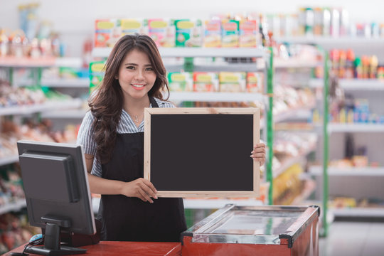 happy cashier with blank blackboard