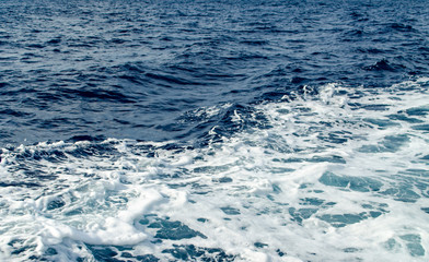 Obraz premium A Blue Trail Waves Surface Foam of Cruise Line After Speed Boat Passing in Ocean with Beautiful Blue Sky Background.