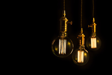 Three filament light bulbs with copy space on black