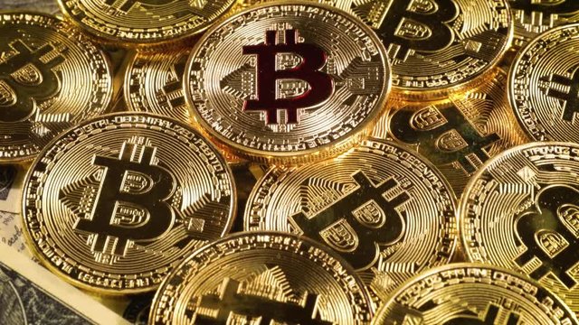 Gold Bit Coin BTC coins and dollar bills.