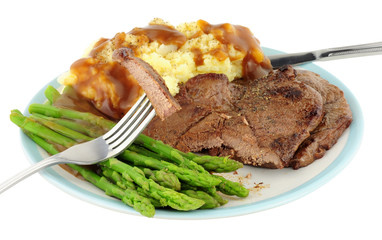 Fried venison steak meal with mashed potatoes and asparagus isolated on a white background