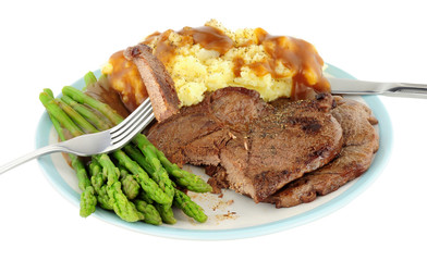 Fried venison steak meal with mashed potatoes and asparagus isolated on a white background