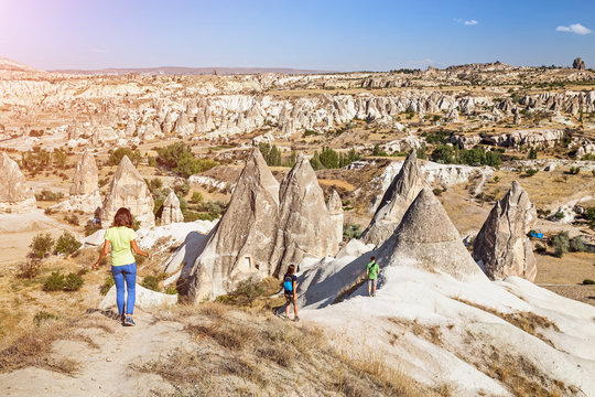 Group of happy caucasian Friends travelling among Cappadocia fairy chimneys at summer