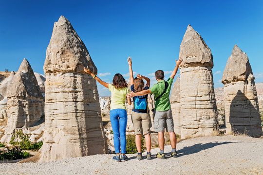 Group of happy caucasian Friends travelling among Cappadocia fairy chimneys at summer