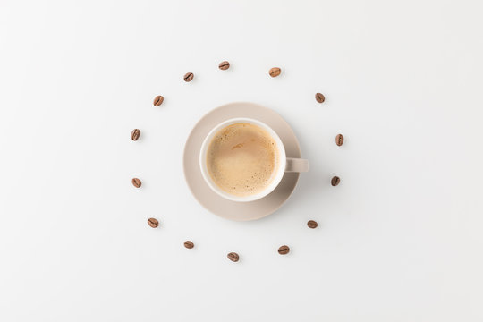 coffee cup surrounded with beans