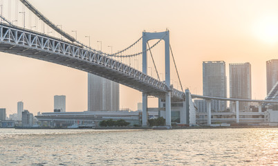 Fototapeta premium TOKYO - MAY 2016: Tokyo Rainbow Bridge at sunset. The city attracts 20 million people every year