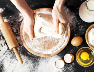 Making dough by female hands at bakery