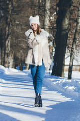 Fototapeta na wymiar Girl in hat and mittens smiling in the winter