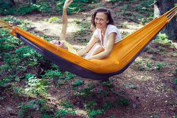 Happy mom and daughter playing in a hammock