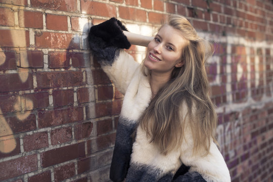 Portrait of smiling young woman wearing artificial fur jacket
