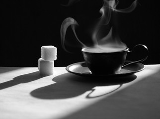 a cup of coffee with hot steam, a black and white still-life with coffee and sugar, a stylish still-life with coffee