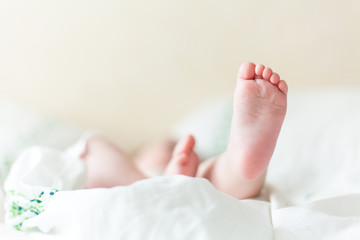 Baby feets in white bed