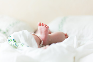 Baby feets in white bed