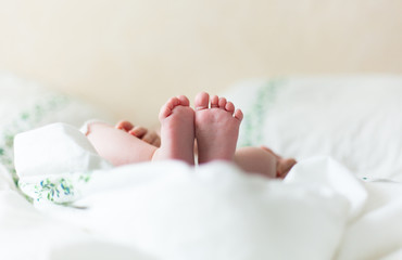 Baby feets in white bed