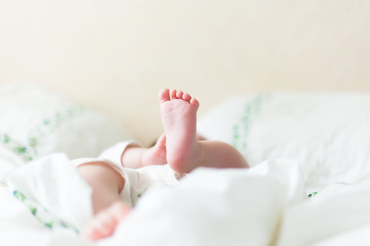 Baby feets in white bed