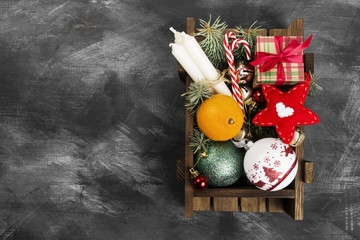 Boxes with gifts for Christmas and various attributes of holiday on a dark background. Top view, copy space