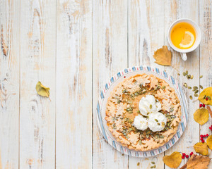 Autumn background with pumpkin pie, hot tea, yellowed leaves, book and rug. Perfect sunny autumn. A wooden light white autumn background for you. Copy Space. Place for text. Flat lay, top view