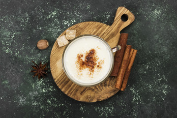Christmas drink eggnog and ingredients on a green background. Top view