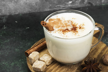 Christmas drink eggnog and ingredients on a green background
