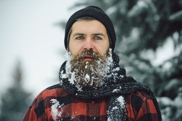Man with beard in winter forest with snow.