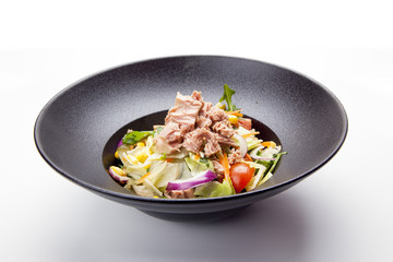 Fresh salad with tuna, tomatoes, eggs, arugula and mustard on white textured background top view. Healthy food.