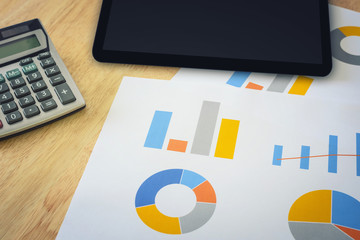 financial graph with calculator and tablet