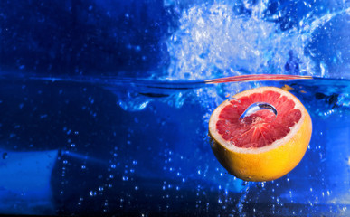 Grapefruit falling in the water. Fresh Grapefruit with a splash 