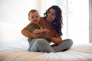 Mother playing with her baby at home