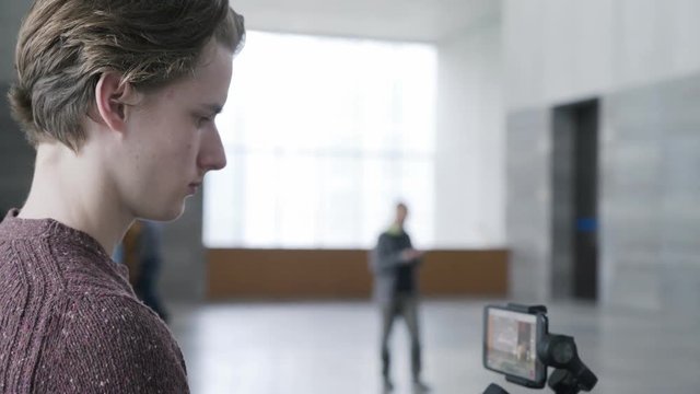 blogger shoots a video for his account using a smartphone with a three-axis stabilizer
