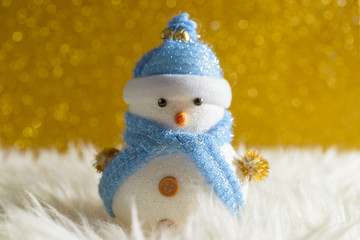 Happy snowman standing in gold winter christmas snow background. Merry christmas and happy new year greeting card with copy-space. Christmas celebration holiday background.