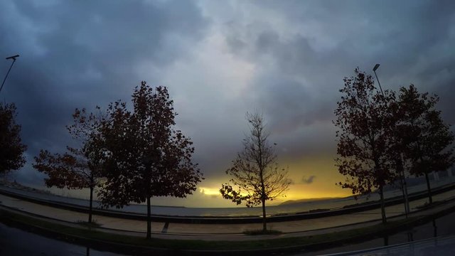 Dark clouds over Alghero seafront at sunset. Time lapse effect