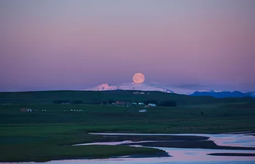 Reise nach Island. Schöne isländische Abendlandschaft mit grünen Feldern, Bergen, Himmel und Mond. © vitaliymateha