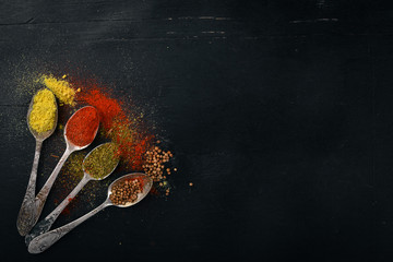 Spices and herbs. A large assortment of spices. Indian cuisine. On the wooden table. Top view. Free space for text. © Yaruniv-Studio