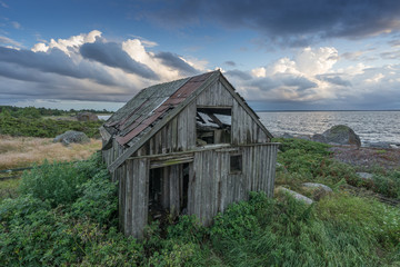 Obraz premium Abandoned houses in the Baltic Sea. Shore, nature and ruins facilities architecture concept. Mohni, small island in Estonia, Europe.