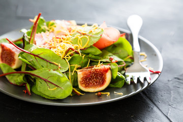 Salad with figs prosciutto and grated cheese
