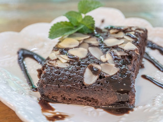 closeup chocolate cake in plate on rustic wooden table