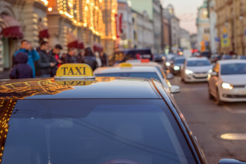 taxi to the center of the city on a busy street with heavy traffic and reflected in the glass evening lights of metropolis