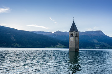 Church under water, drowned village, mountains landscape and peaks in background. Reschensee Lake Reschen Lago di Resia. Italy, Europe, S&uuml;dtirol, South Tyrol, Upper Adige, Alto Adige