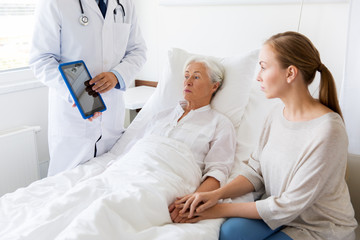 senior woman and doctor with tablet pc at hospital