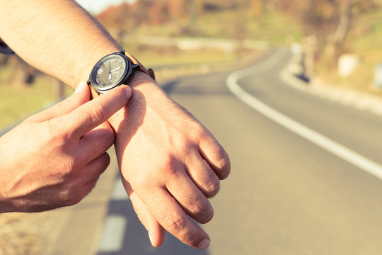 Man Hands Checking Time On Wristwatch On The Road Side