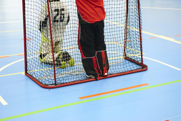 Unidentifiable floorball goalkeeper during match. 